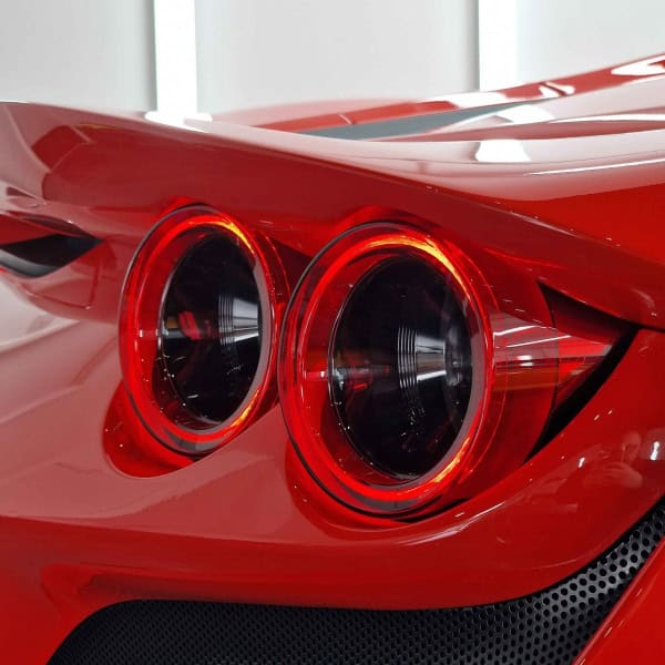 A red Ferrari showing the rear taillights tinted with Xpel paint protection film.